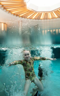 Kinder springen in das Schwimmbecken