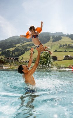 Vater wirft Tochter im Infinitypool hoch