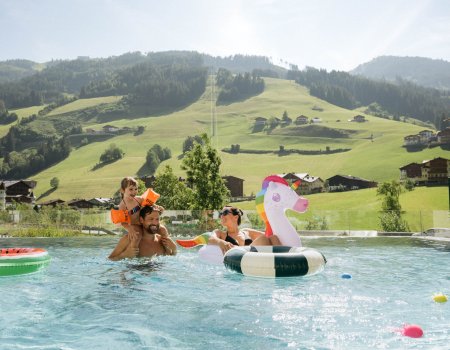 Familie schwimmt und spielt im Infinitypool