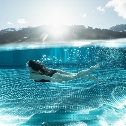 Frau tauch im Pool unter
