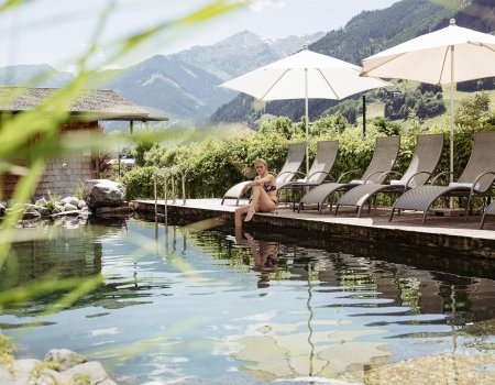 Frau sitzt am Naturbadeteich