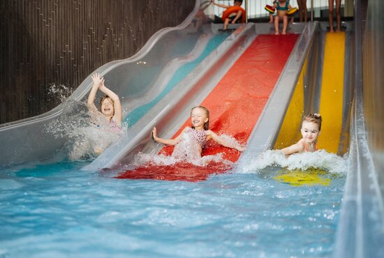 Kinder rutschen die Trioslide Rutsche hinunter