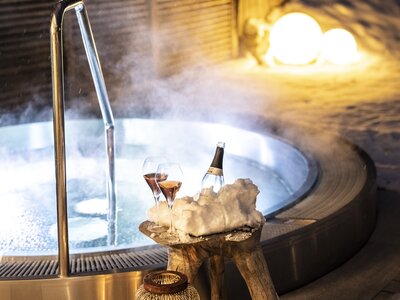 Whirlpool bei Nacht mit Getränken im Schnee
