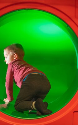 Junge in der Röhrenrutsche
