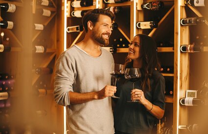 Eltern genießen ein Glas Wein im Weinschauraum