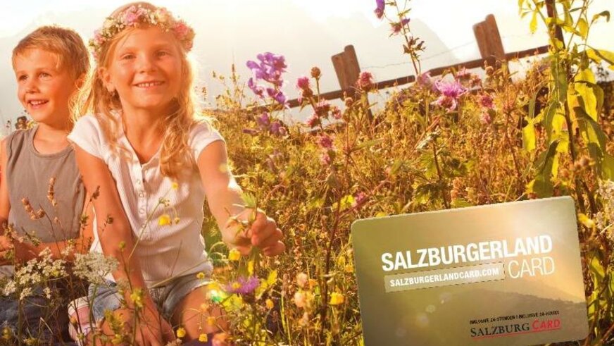 Kinder in Blumenwiese mit der Salzburger Land Card