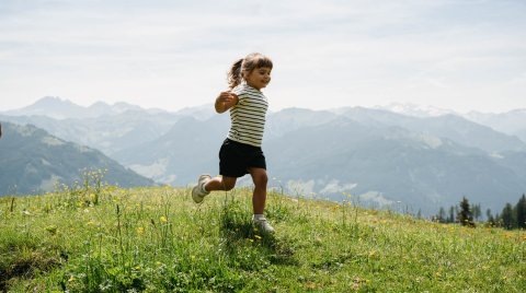 Mädchen läuft über Blumenwiese 