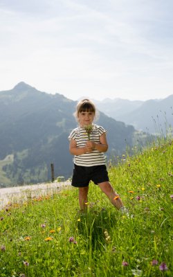Mädchen mit selbst gepflückten Blumen in der Hand
