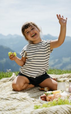 Mädchen beim Picknick auf der Alm