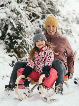 Mutter und Tochter beim Rodeln