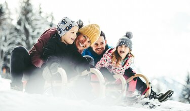 Familie beim Rodeln
