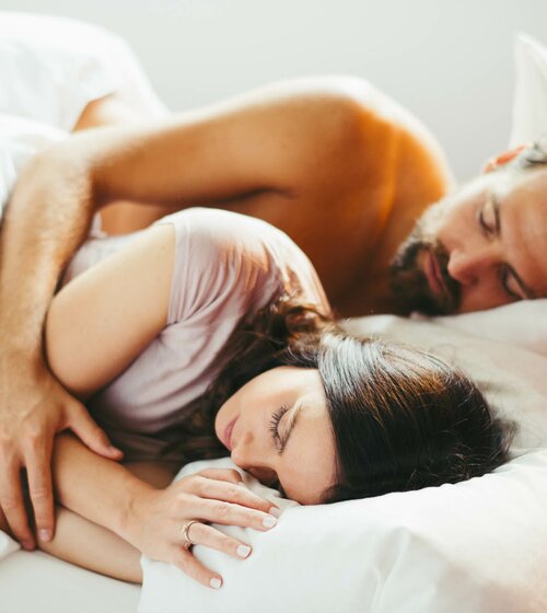 Pärchen kuschelt im Bett